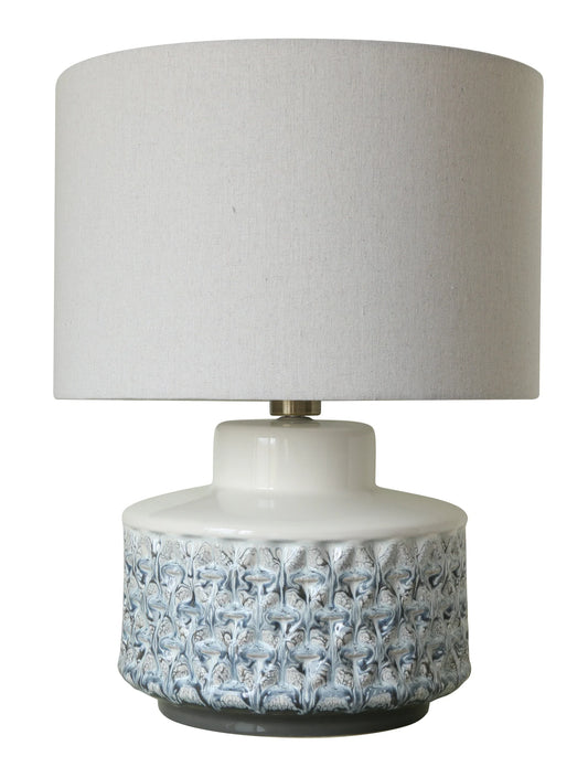 Table lamp with textured white base and grayish-white shade on a white background