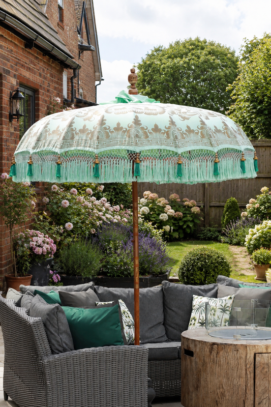 Riviera Mint handmade Balinese-style garden parasol styled with grey rattan patio seating in an English garden