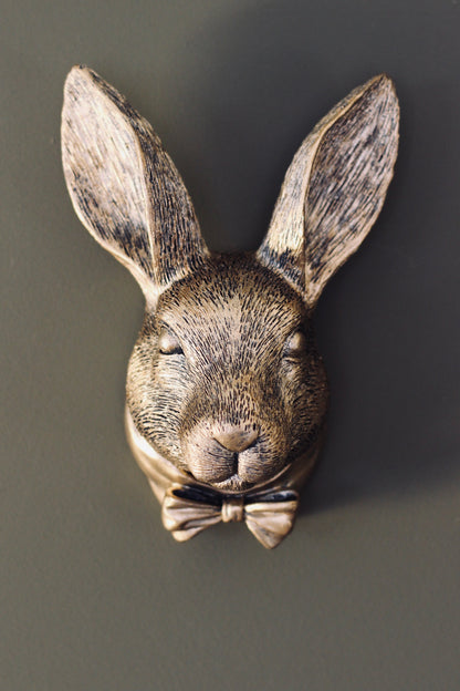 Small rabbit wall bust in an aged gold finish displayed on a dark wall