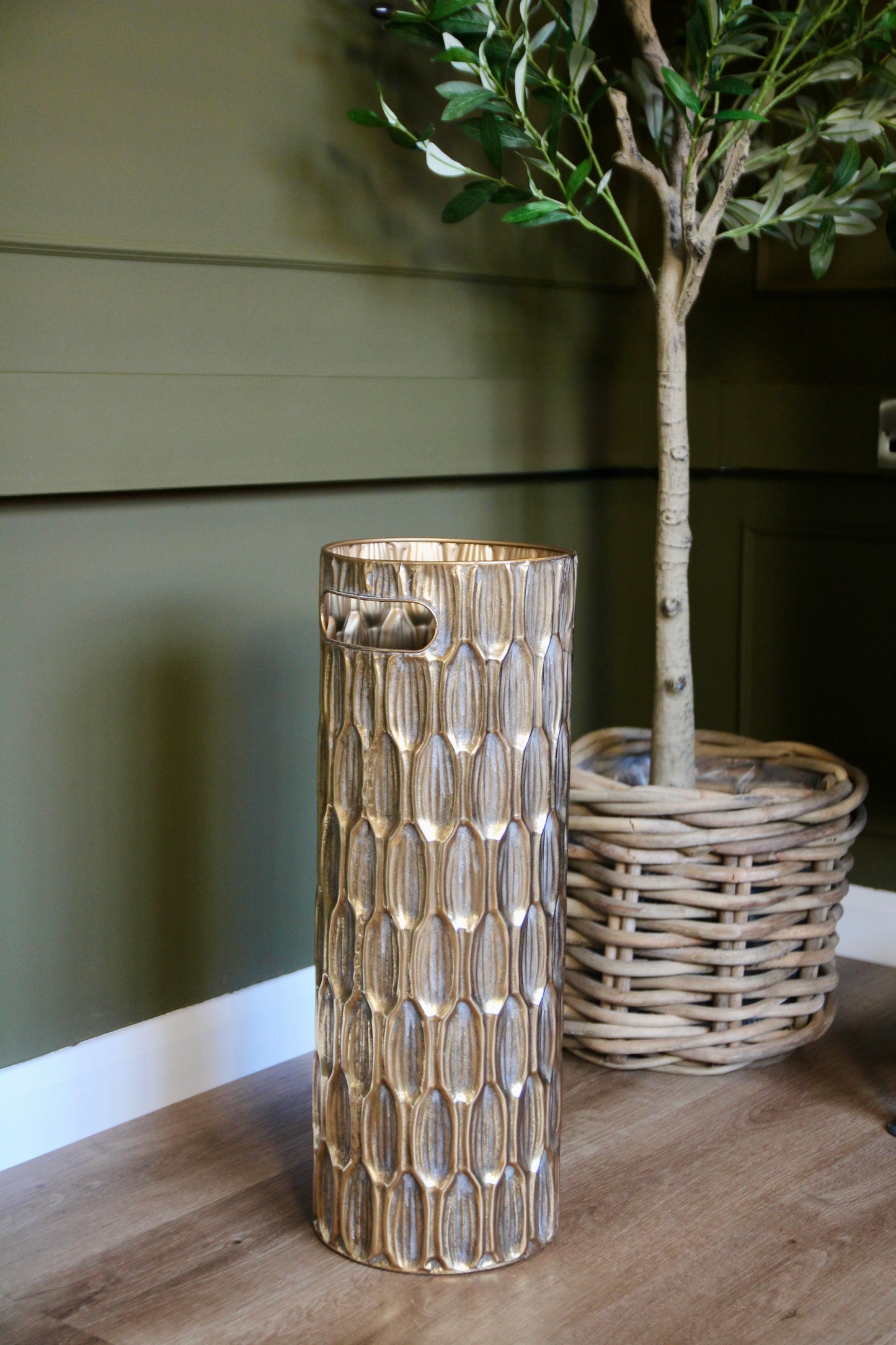 Gold umbrella holder shown from an alternative angle, highlighting its cylindrical shape.