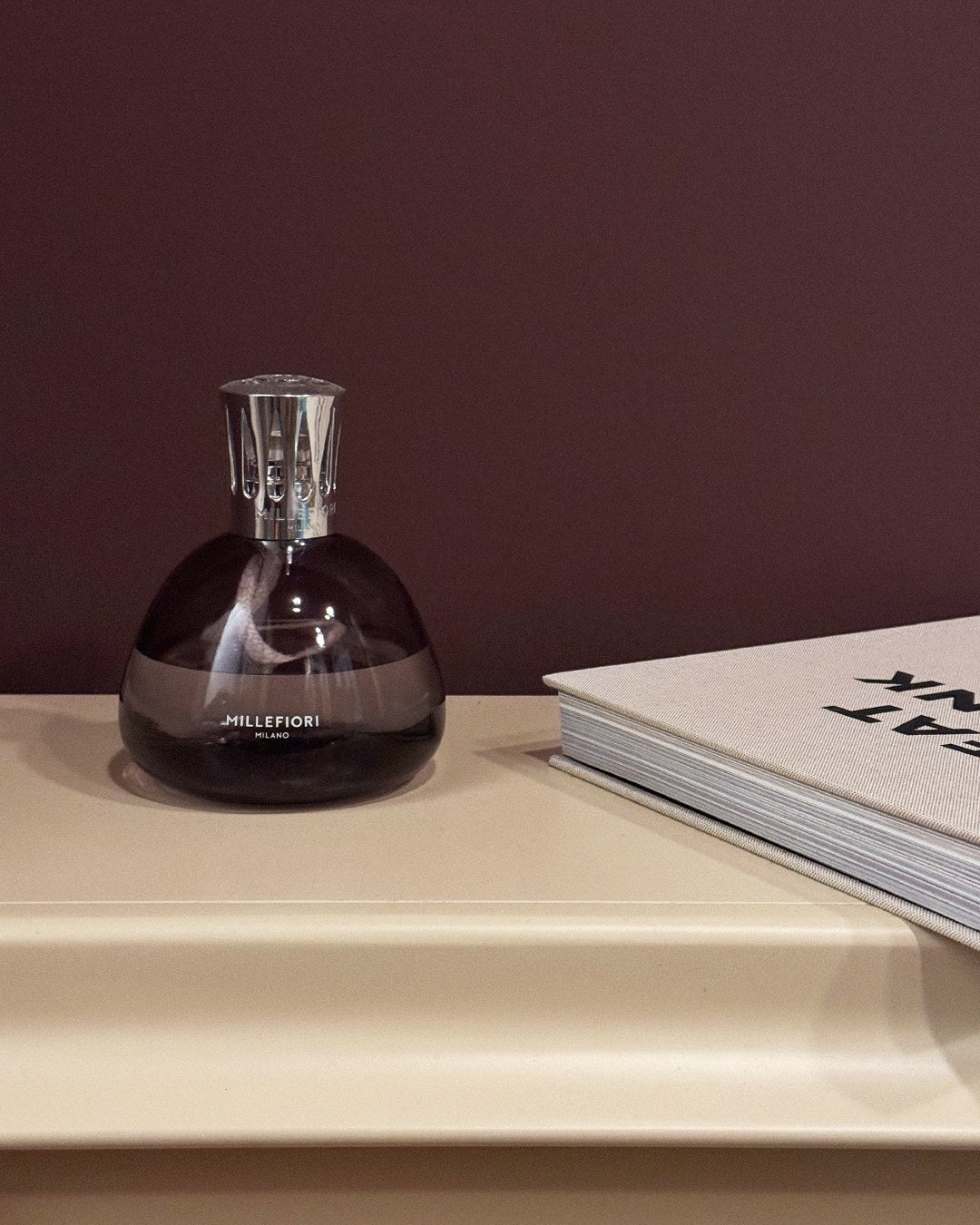 Millefiori Smokey Grey Fragrance Lamp styled beside interiors book